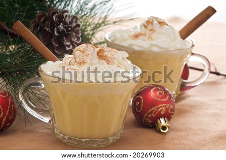 Festive drink of eggnog with whipped cream and cinnamon.