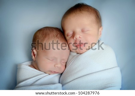 sleeping newborn twins, on blue blanket