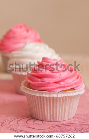 Pink and white vanilla birthday cupcakes on pink table