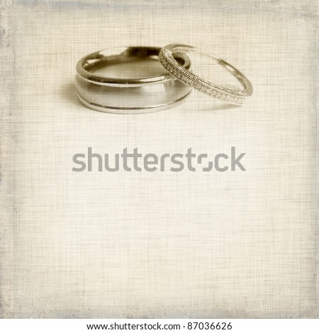 stock photo vintage wedding invitation with two rings on sepia textured 