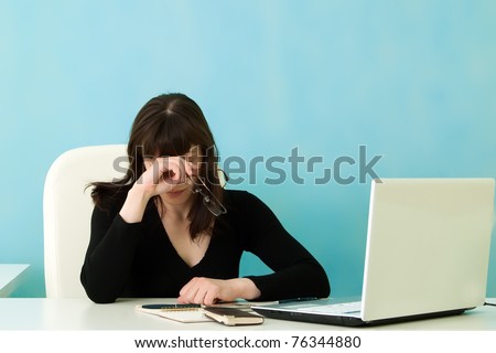 Tired woman in office on a blue  background