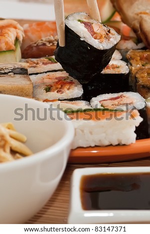 Traditional Japanese food Sushi. Chopstick, sushi on orange plate and sauce on bamboo napkin. Sushi collection