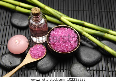 Bamboo grove and salt in bowl with candle with massage oil on mat