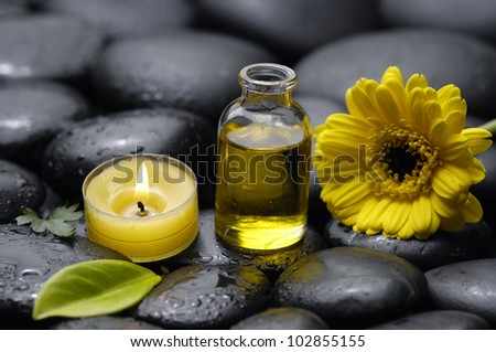 spa concept with zen stones with gerbera and massage oil with candle on pebbles