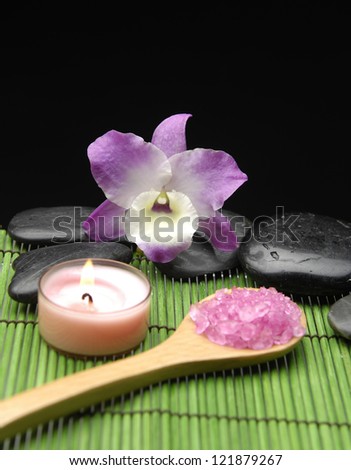zen basalt stones and sea salt in spoon with candle on green mat