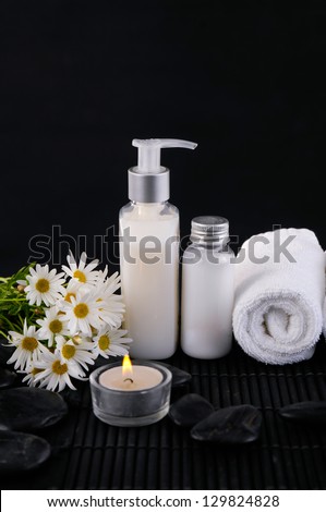 daisy flowers and towel, massage oil ,zen ,candle ,stone on mat