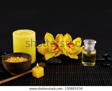 Spa sitting with candle ,massage oil, orchid ,pebbles ,salt in bowl on mat