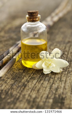 White Gardenia Blossom with spa oil and dry bamboo grove on driftwood