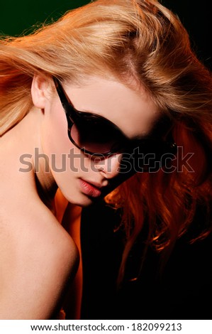 Sexy model in sunglasses on black background