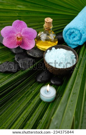 Spa set with spa oil ,towel salt in bowl , orchid on palm leaf