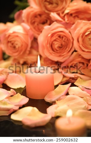 rose petals with branch rose with two candle in bowl