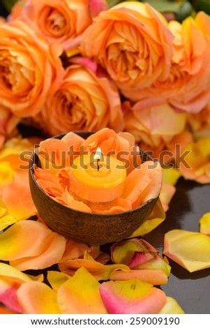 Rose with many rose petals with candle in bowl