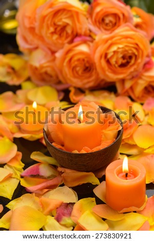 Rose with many rose petals with candle in bowl