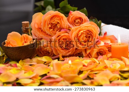 Orange rose petals with candle, bowl ,towel and branch rose