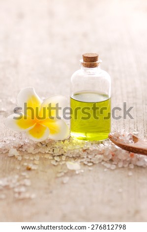 Spa setting frangipani with massage oil ,pile of salt,spoon