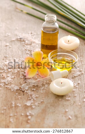 Spa setting with frangipani, oil and pile of salt,candle,green plant