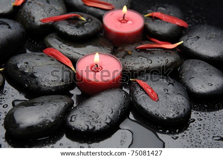 Spa Stones and red gerbera petals with two red candle
