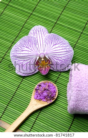 Pink orchid and bath salt in spoon flower and towel on mat