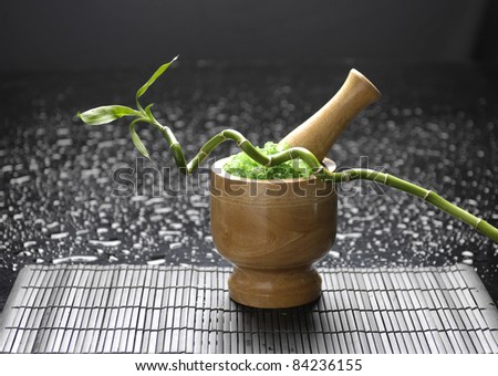 wooden mortar and pestle with lucky bamboo on mat