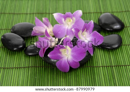 Set of beautiful orchid and zen stone on bamboo stick straw mat