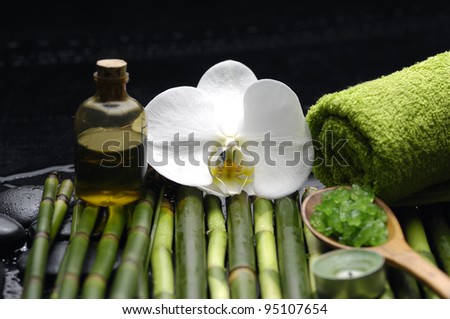 Spa setting-salt in spoon and orchid with candle on bamboo Spa setting-salt in spoon and orchid with candle on bamboo