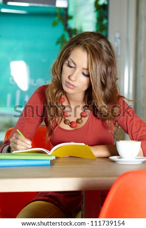 Young beautiful student girl  in the cafe