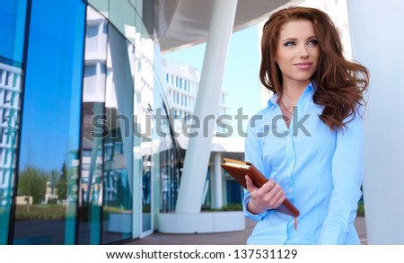 young businesswoman standing in front of office buildings