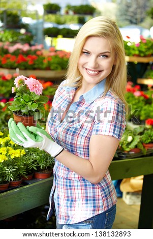 Woman shopping for and looking at plants in garden center
