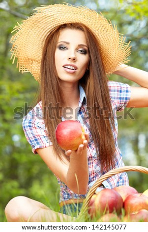 Apple woman. Very beautiful ethnic model eating red apple in the park.