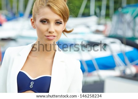 sexy fashionable woman standing in a port fashion style, yachts