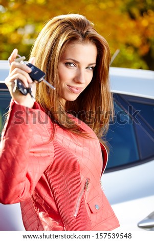 Car driver woman smiling showing new car keys and car.