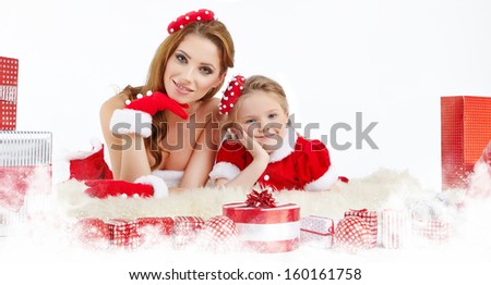 Beautiful woman and little girl dressed in costume santa claus