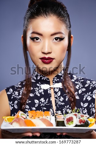 Young beautiful asian woman eating sushi,