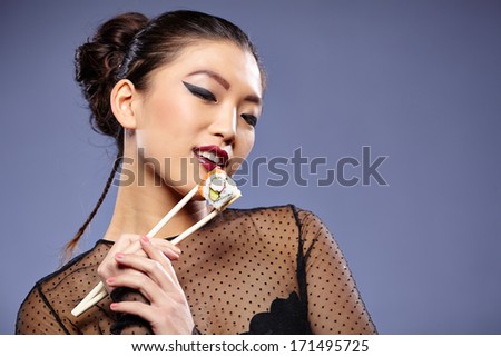 Sushi woman holding sushi with chopsticks
