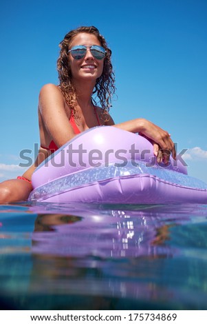 Young perfect woman on an air mattress in the sea