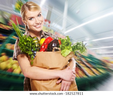 Young woman with a grocery shopping bag. Shop background.