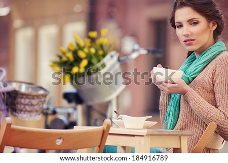 Woman drinking coffee in a cafe on the streets of Paris