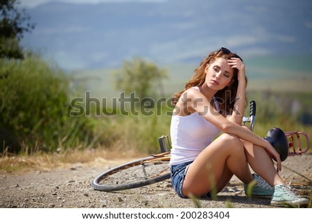 beautiful smiling girl sitting next to bike, summer time