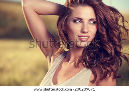 Portrait of a  woman on golden cereal field in summer