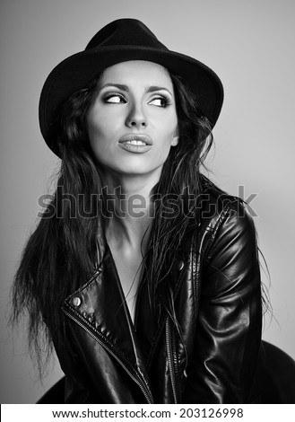 woman in leather jacket and hat, studio B/W shot.