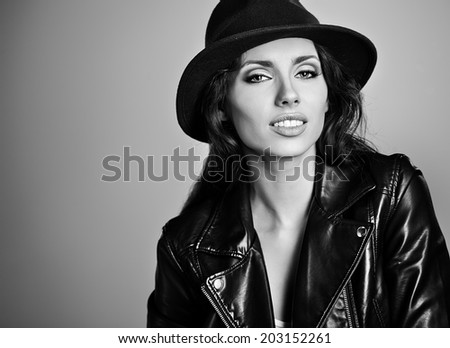 woman in leather jacket and hat, studio B/W shot.