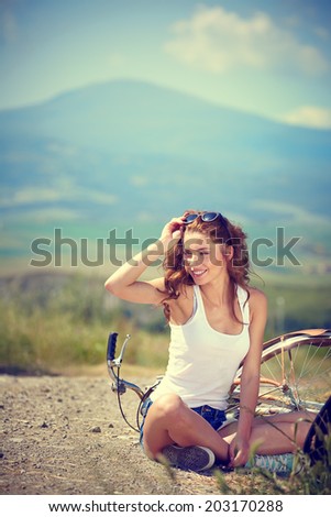 beautiful vintage girl sitting next to bike, summer time
