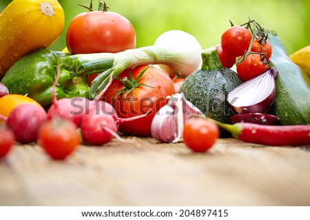 Fresh organic vegetables ane fruits on wood table  in the garden