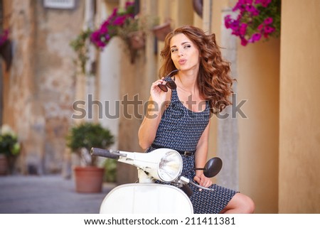 Young beautiful italian woman sitting on a italian scooter.