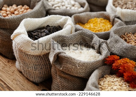 Corn kernel seed meal and grains in bags isolated on a wood table