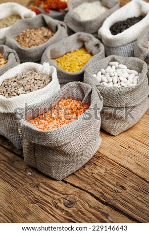 Corn kernel seed meal and grains in bags isolated on a wood table
