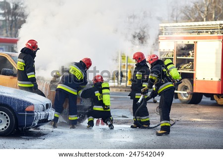 Warsaw, Poland - January 27, 2015: Firefighters are extinguishing a car on fire at main road in Warsaw.