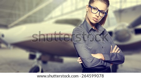 Business woman wearing sunglasses against private jet