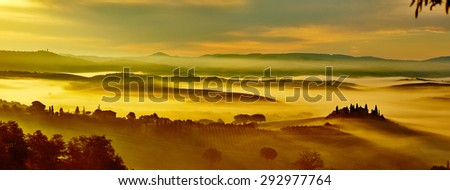 Scenic Tuscany landscape panorama with rolling hills and valleys in golden morning light.