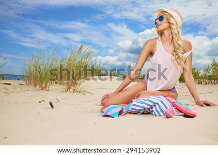 long blonde haired girl in bikini on  beach
